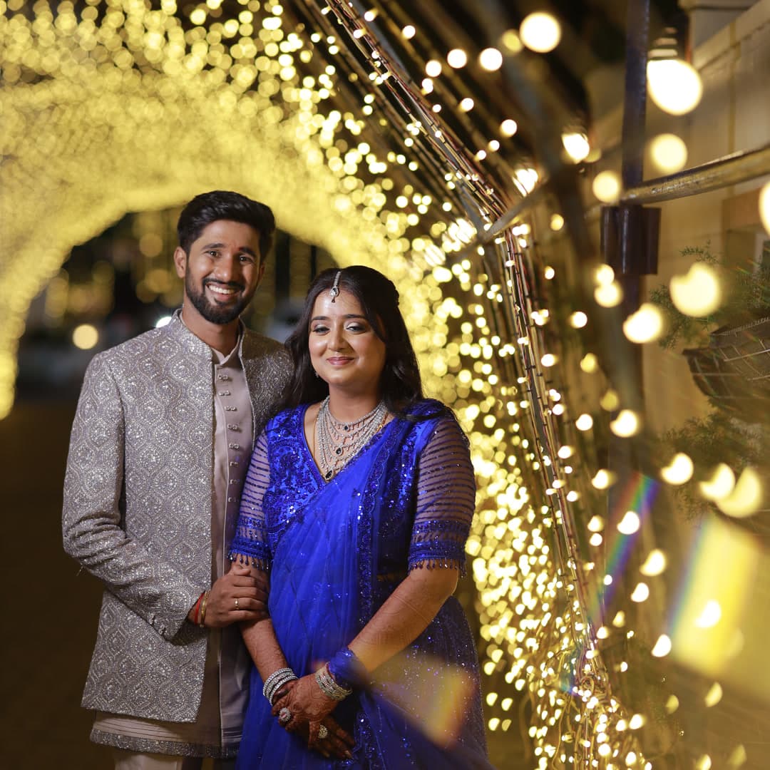 Couple standing in a golden fairy light tunnel