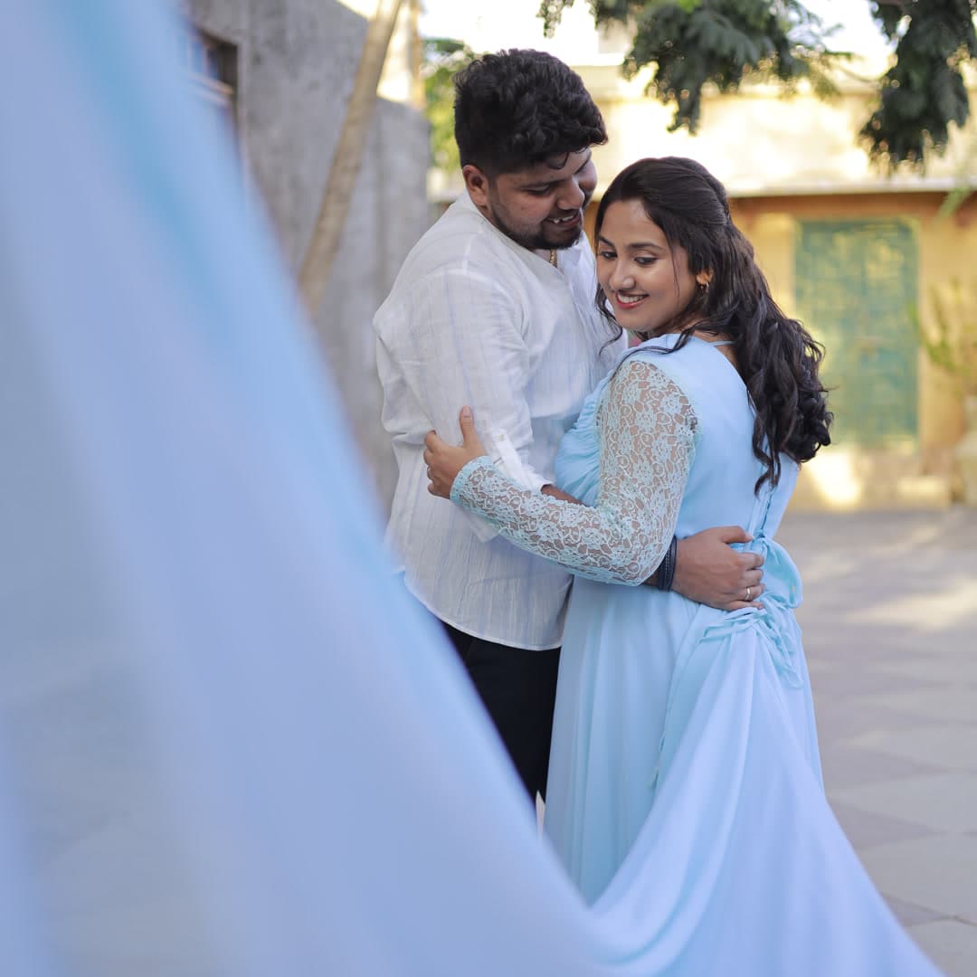 Couple outdoors with billowing pastel blue gown train