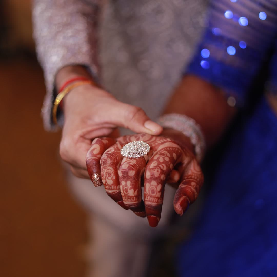 Detailed view of henna patterns on hands and a diamond ring