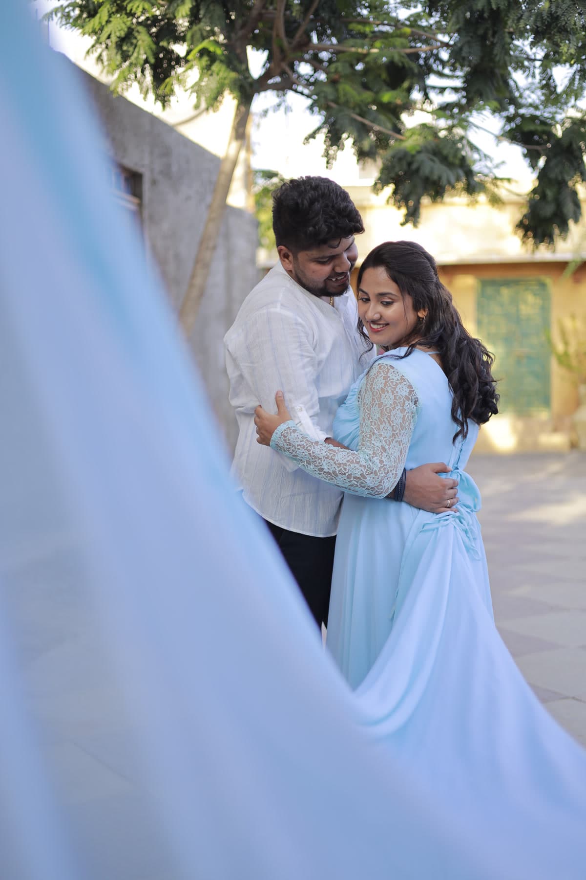 Couple outdoors with billowing pastel blue gown train